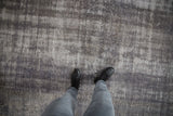The dynamic texture of a distressed charcoal Oushak rug with a faint roundel medallion.