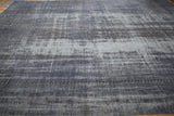 Faint roundel medallion detail visible through the heavily worn pile of a distressed Oushak carpet.