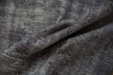 The dynamic texture of a distressed overdyed Oushak rug in shades of charcoal and ivory.