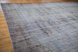 Distressed Oushak carpet, worn pile with visible foundation, faded blue and mauve vinery.