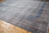 Distressed texture of a vintage Oushak carpet with worn blue and mauve hues, foundation visible.