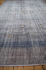 Distressed vintage Oushak carpet in dusty blue and mauve, showcasing faded patterns and worn texture.