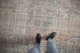 Distressed vintage Turkish Sparta carpet with faded palmette motif and dusty blush tones.