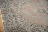 Distressed Sparta carpet's floral arabesque border, corner spandrel, dusty denim, and blush tones.
