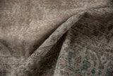 Folded vintage Sparta carpet, showing distressed low pile with time-softened silver and blue hues.