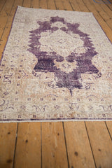 Vintage Distressed Sparta rug: worn aubergine medallion, ivory field, foundation showing through.