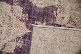 Distressed Sparta rug's aubergine and ivory pile texture, revealing hand-knotted back.