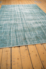Distressed Oushak rug texture in dusty turquoise, ivory, charcoal, and fringe.