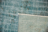Distressed Oushak rug pile in dusty turquoise and ivory, showing wear, tightly woven back, and fringe.