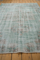 Distressed Oushak rug texture with wear to foundation in jade green, ivory, and brown.