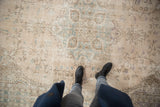 Distressed vintage Sparta carpet with faded ivory, pale teal, and aubergine vinery.
