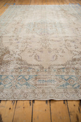 Vintage distressed Turkish Sparta carpet detail with faded ivory, teal, and aubergine floral vinery.