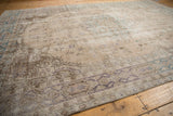 Distressed vintage Sparta carpet showing faded aubergine vinery and pale teal border details.