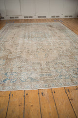 Close-up of distressed Turkish Sparta carpet's secured end, faded teal vinery and wear.