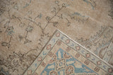 Distressed vintage Turkish Sparta carpet fold, showing faded pile and border with pale teal and pink.