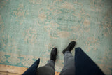 Pale turquoise and ivory distressed Oushak rug, showing even wear and faint foundation underfoot.