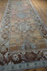Coffee brown geometric border and distressed pale gold field with faded slate blue vine motifs.