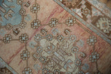 Distressed vintage Oushak rug detail with abrash, dusty rose, pale gold, and slate blue motifs.