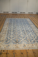 Distressed Sparta rug with denim blue lattice and worn antique ivory border.