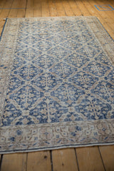 Distressed vintage Sparta rug detail, dusty denim blue lattice, worn pile, foundation visible.