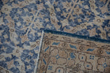 Distressed dusty denim blue rug pile, foundation showing through, with hand-knotted back.