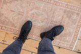 Worn hand-knotted texture of a distressed Oushak rug in muted antique ivory.