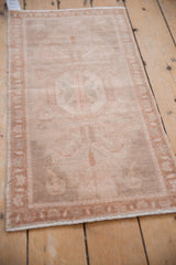 Distressed vintage Oushak rug's intact side selvage and low, worn pile texture.