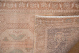 Detail of vintage distressed Oushak rug showing worn antique ivory pile and hand-knotted foundation.