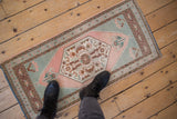 Distressed vintage Oushak rug showcasing blush hexagonal floral medallion and seafoam green spandrels.