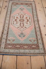 Distressed Oushak rug, blush corner spandrel with seafoam field and coffee brown floral border.