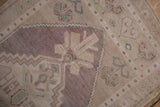 Stepped contour and faded floral motifs in pale lavender, beige on a distressed Oushak rug.