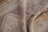 Pile texture of the distressed vintage Oushak rug showing stepped contours in pale lavender and beige.