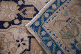 Folded Vintage Distressed Oushak rug displaying cobalt blue border, soft beige pile, and intact fringe.