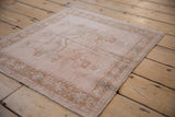 Distressed vintage Oushak rug mat with low pile and tiered leaf border detail.