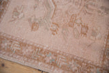 Distressed Oushak rug detail: pale coffee brown pile with even wear and silver accents.