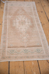 Distressed ivory and beige Oushak rug with stepped medallion and seafoam green accents.