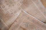 Distressed vintage Oushak rug pile, showing even wear, corded selvage, and subtle seafoam.