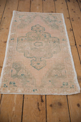Textured ivory and faded seafoam green pile with worn pattern on a distressed Oushak rug.
