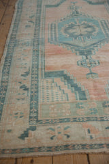 Vintage Oushak rug detail with abrashed cantaloupe field and geometric seafoam green border.