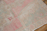 Close-up view of the worn, hand-knotted pile on a vintage Oushak runner with Rococo-style patterns.