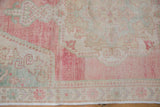 Evenly worn texture showing knot heads on the Rococo spandrel of a vintage Oushak.