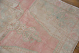 Faint foundation showing through the evenly worn pile of a distressed vintage Oushak runner.