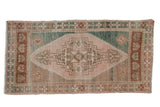 Distressed vintage Oushak rug, stepped medallion, geometric floral motifs in muted green, beige, pink.