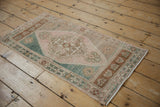 Distressed Oushak rug's surface, showing geometric medallion and soft ocean green hues.