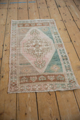 Vintage distressed Oushak rug, stepped geometric floral medallion in muted beige, green, bronze.