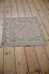 Faded serrated leaves and floral patterns on a distressed vintage Oushak square rug.