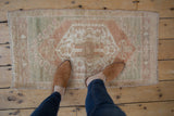 Vintage Oushak rug with distressed medallion in faded beige, dusty seafoam, pale copper.