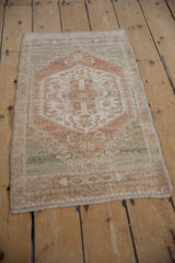 Distressed Oushak rug mat with a faded medallion, featuring muted beige, seafoam, and copper tones.