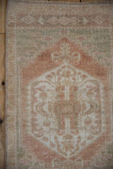 Textured, distressed Oushak rug pile with faded beige, pale copper, and dusty seafoam motifs.