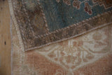 Distressed textures of the vintage Oushak rug showing dusty seafoam and pale copper wear.